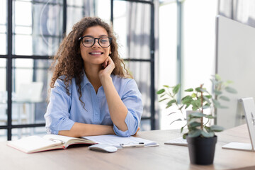 Smiling businesswoman looking at camera, make conference or business call, recording video blog, talking with client.