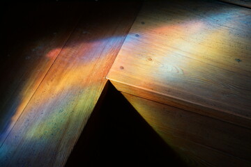 colorful background from the stained glass window in a church on the wood benches 