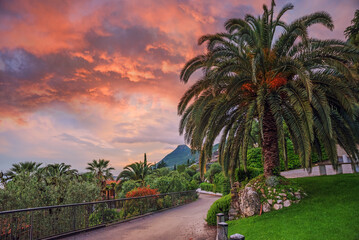 mediterranean landscape with palm trees, tourist resort Gargnano, beautiful sunset sky