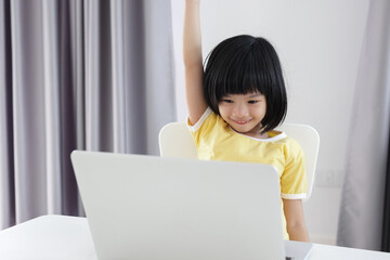 little asian girl student study online using laptop computer at home