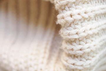closeup beige knitted woolen fabric texture background
