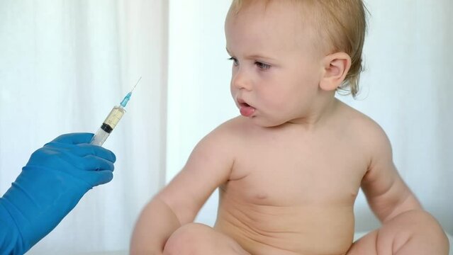 Doctor vaccinating baby in clinic. Little baby get an injection. Pediatrician vaccinating newborn baby. Vaccine for infant child. Child's Immunization, Children's Vaccination, Health concept.