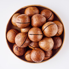 fresh macadamia nuts on a white acrylic background