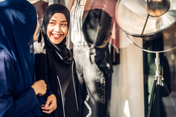 Two young asian fashion muslim woman enjoying shopping time summer sale walk and having fun talking together to buy something in the shop at fashion store