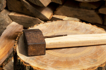 The ax lies on a log next to the firewood