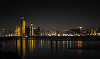 Fototapeta na wymiar Abu Dhabi skyline and its reflection in water at night