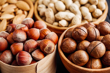 set of different nuts on a black rustic wooden background