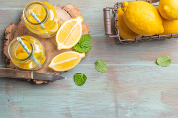 Glass of homemade lemonade with mint and lemon wedges. Top view with copy space.