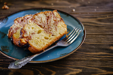 Home pound cake with lemon and strawberry filling on a blue plate on a wooden table.