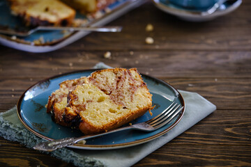 Home pound cake with lemon and strawberry filling on a blue plate on a wooden table.