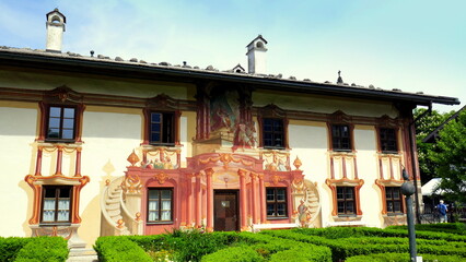 Pilatushaus im grünen Park in Oberammergau mit perspektivischer Lüftlmalerei unter blauem Himmel