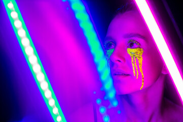 Cyberpunk. Girl with stylized makeup in the light of neon lamps.