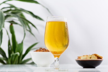 One glass beer and snacks on light table copy space