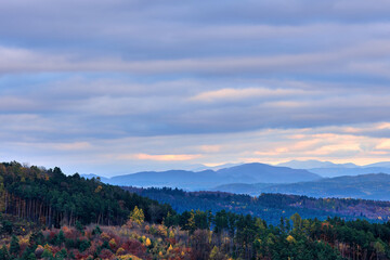 Autumn mountain landscape with forest and colorful sky at sunset. Vrsatec, Slovakia.