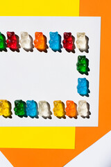 Flay lay of delicious gummy bears on colorful background.