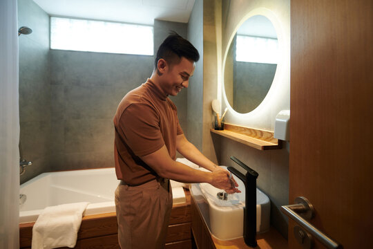 Positive Young Man Washing Hands After Coming Home From Work