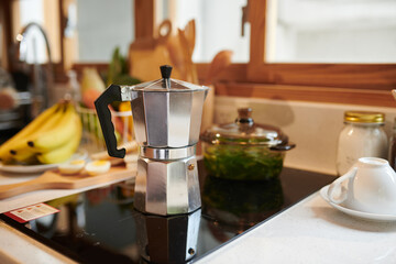 Moka pot on stove in kitchen, morning routine concept