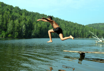 boy jumping in lake