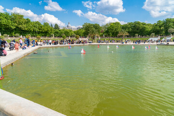 Fototapeta na wymiar Paris, France - April 24, 2022: Small boats to float in the fountain in the garden of Luxembourg, one of the most beautiful gardens in Paris