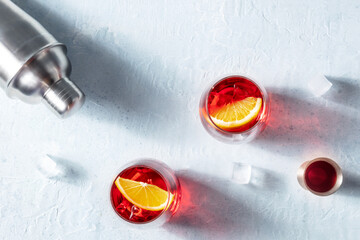 Campari orange cocktails with a jigger and a shaker, summer party drinks on ice with copy space,...