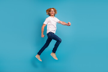 Fototapeta na wymiar Full length photo of overjoyed active person jumping rush fast have good mood isolated on blue color background