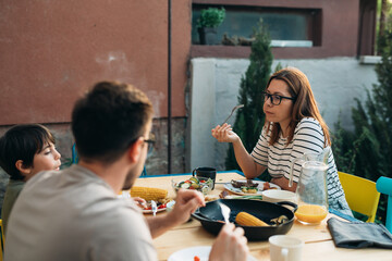 family of three having lunch outdoor in garden