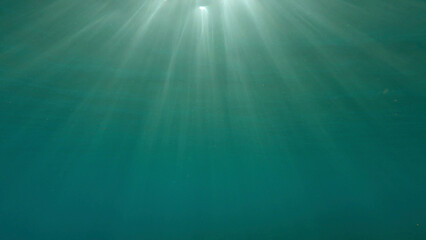 Sunrays penetrate through the surface of the water. Underwater light creates a beautiful veil, consisting of sunlight. range rays of the sun at sunset under the surface of the water. Red sea, Egypt