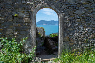 doorway in stone antique wall overlooking the sea