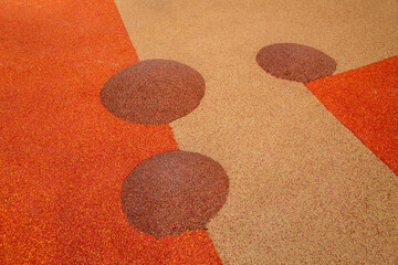 Children's mounds covered with rubberized orange-pink coating on the playground on a clear sunny day. Sports Recreation Entertainment.