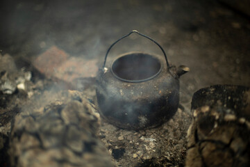 Kettle on fire. Cooking tea on coals. Camping details.