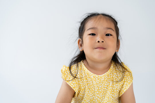 portrait of pleased preschooler and asian girl looking at camera isolated on grey.