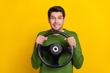 Portrait of attractive nervous worried guy holding steering wheel riding isolated over bright...