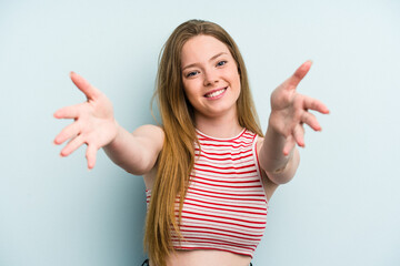 Young caucasian woman isolated on blue background showing a welcome expression.