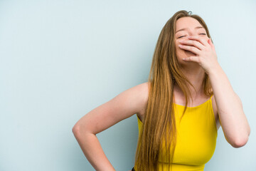 Young caucasian woman isolated on blue background laughing happy, carefree, natural emotion.