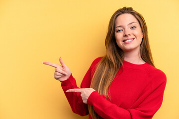 Young caucasian woman isolated on yellow background excited pointing with forefingers away.