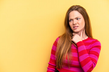 Fototapeta premium Young caucasian woman isolated on yellow background touching back of head, thinking and making a choice.