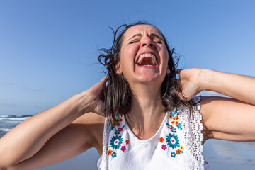 Excited female laughing at joke on beach