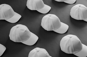pattern of white baseball caps on a dark background.