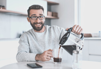 attractive man pouring himself a Cup of morning coffee