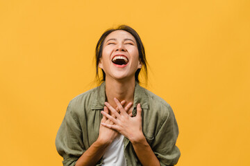 Young Asia lady feel happiness with positive expression, joyful surprise funky, dressed in casual cloth isolated on yellow background. Happy adorable glad woman rejoices success. Facial expression.