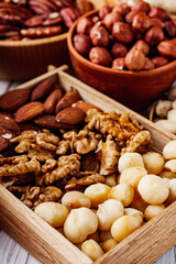 set of different nuts on a white wooden rustic background