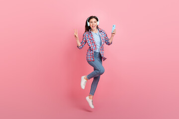 Full size photo of good mood overjoyed lady show v-sign say hello surfing in phone isolated on pink color background