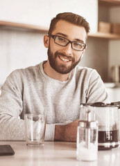 attractive man sitting at the kitchen table in the morning
