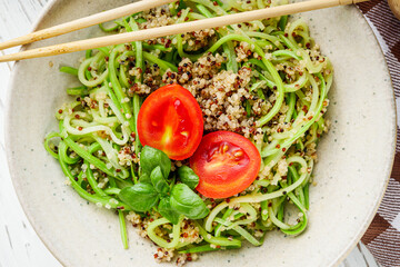 zucchini noodles with quinoa on a white background