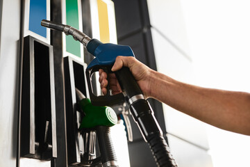 Crop worker holding gas pump nozzle at service station