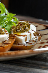 Caprese salad. Tomatoes, mozzarella cheese, basil leaves and pesto sauce.