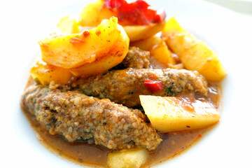 Juicy Meatballs. Meatballs with tomato and patatoes in white plate isolated. Traditional turkish meat dish.