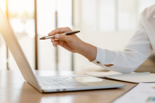 Close up business hands pointing on laptop screen or planning strategy work.