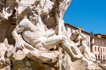 Statue of naked Neptune carved in a marble fountain in Rome