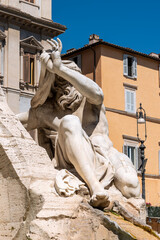 Close-up on ancient marble statue decorating a fountain in Rome showing a man covering his head